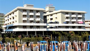 A multi-story hotel with balconies and air conditioning units.