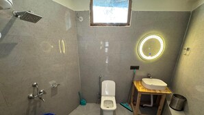 Une petite salle de bain comprenant des toilettes, un lavabo et une douche.