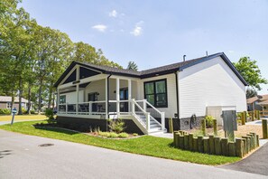 Une maison de plain-pied avec un porche, un escalier et un petit jardin.