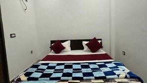A bedroom with a bed, a headboard, a wall-mounted air conditioning unit, and a ceiling with a cross design. - Radhe Ji Home Stay By Wishotel, Kharagpur, India (Faizabad)