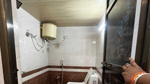 A bathroom with a toilet, a shower, and a hand dryer. - Radhe Ji Home Stay By Wishotel, Kharagpur, India (Faizabad)