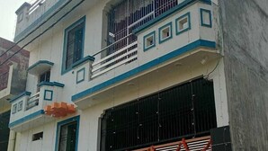 A two-story building with a balcony on the upper floor, a large garage door, and a gated entrance. - Radhe Ji Home Stay By Wishotel, Kharagpur, India (Faizabad)