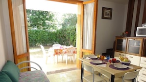 Une pièce confortable avec un canapé, une table à manger pour quatre personnes et un coin cuisine équipé d’un four à micro-ondes.