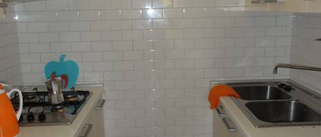 Kylskåp, mikrovågsugn, spishäll och grytor/köksredskap