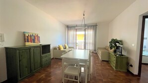 A compact living space with a dining table, sofa, and a cabinet.