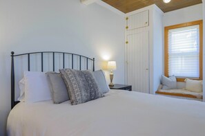 A neatly made bed with a headboard, a bedside lamp, and a window with blinds. - The Porch House, hot tub, pet friendly, historic! (Crested Butte)