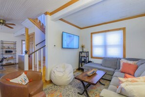 A living room with a sofa, a bean bag, a coffee table, and a TV. - The Porch House, hot tub, pet friendly, historic! (Crested Butte)