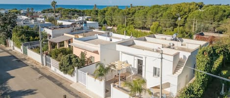 Una zona residencial con casas modernas, una calle y vistas al mar.