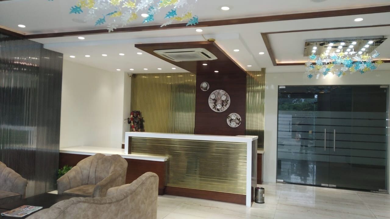 A reception area with a modern design, featuring a reception desk, seating area, decorative wall panels, and a glass door entrance.