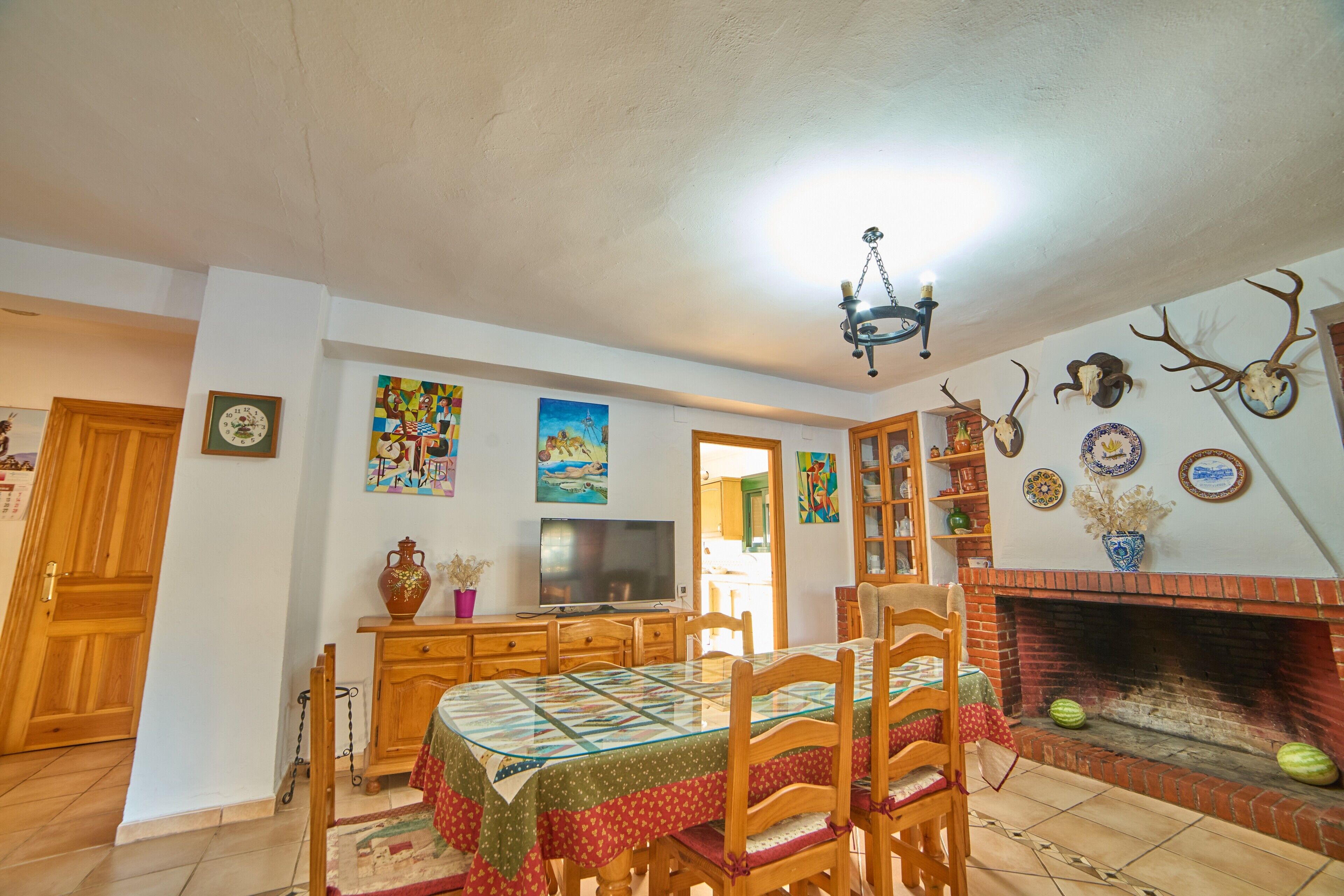 Un comedor con una mesa, sillas, un televisor y una chimenea.