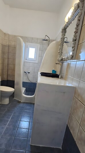 A bathroom with a bathtub, a toilet, and a shower. - Studio Apartment 'Pleasure View  1' with Mountain View, Wi-Fi and Air Conditioning (Perissa)