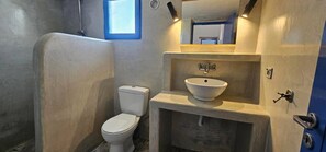 Ein Badezimmer mit Toilette, Waschbecken und Dusche.