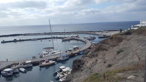 Un port de plaisance avec des bateaux amarrés, une jetée qui s’avance dans l’eau et un bâtiment situé sur la droite.