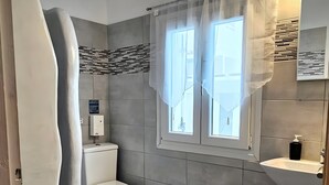 A modern bathroom with a toilet, sink, and shower area.