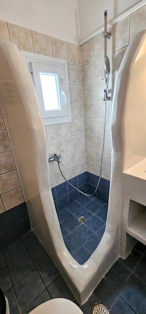 Un baño con bañera independiente, una ventana y zona de ducha.
