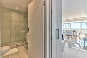 Ein modernes Badezimmer mit Duschkabine aus Glas, Toilette und Waschbecken.