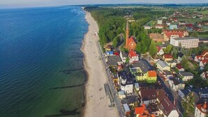 Ilmakuva rannikkokaupungista, jossa näkyy ranta, taloja ja kirkko.