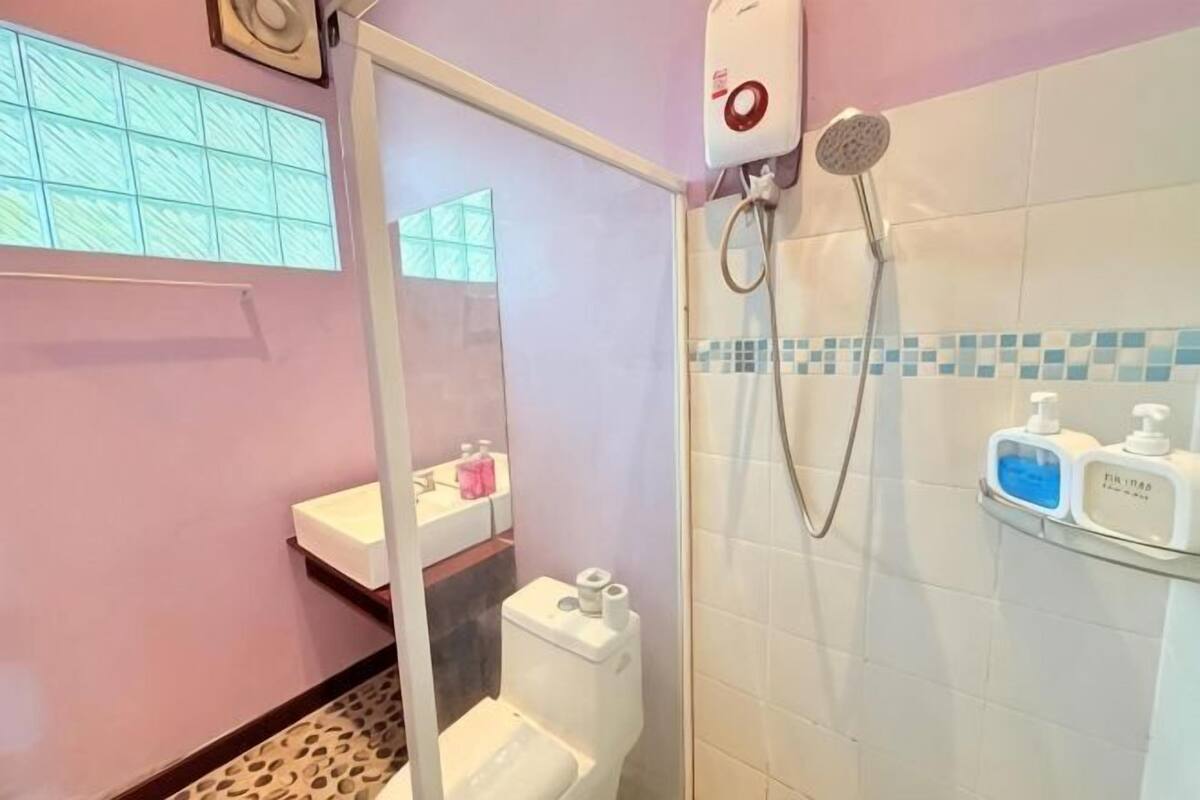 A bathroom with a toilet, a shower, and a sink.