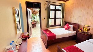 Ein Hotelzimmer mit Bett, Nachttisch und einem kleinen Schreibtisch, inklusive Spiegel und Pflegeartikeln.