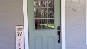 A front door with a 'WELCOME' sign, a mailbox, and a house number '44'. - Charming 3-bedroom house in enchanting St. Augustine with AC (St. Augustine)