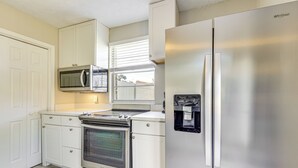 A kitchen with white cabinetry, a stainless steel refrigerator, a built-in microwave, and a double oven. - Waterfront JAX Townhome w/ River Access! (Jacksonville)
