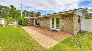 A single-story house with a brick exterior, a covered patio area, and a lawn. - Waterfront JAX Townhome w/ River Access! (Jacksonville)