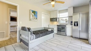 A compact bedroom with a bed, a ceiling fan, and a kitchenette with a microwave, oven, and refrigerator. - Waterfront JAX Townhome w/ River Access! (Jacksonville)
