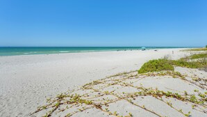 A wide sandy beach with clear blue sky and calm sea. - Beachfront Bliss + Bbqs! Indian Rocks Beach Escape (Indian Rocks Beach)