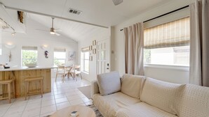 A spacious living area with a sofa, a dining table, and a kitchen area. - Beachfront Bliss + Bbqs! Indian Rocks Beach Escape (Indian Rocks Beach)