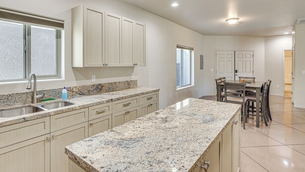 A modern kitchen with granite countertops, light wood cabinets, and a dining area with a table and chairs. - Hike & Explore: Apt 3 Mi to Lake Havasu & Dtwn! (Lake Havasu City)