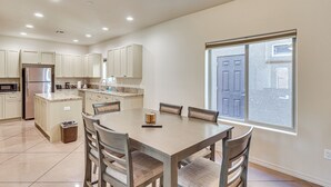 A modern kitchen with built-in appliances, a dining area with a large table and chairs, and a window with a view of the outside. - Hike & Explore: Apt 3 Mi to Lake Havasu & Dtwn! (Lake Havasu City)