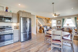 A spacious kitchen with modern appliances, a dining area with wooden furniture, and a staircase leading to a living area. - 10 Mi to Slopes! Mtn-view Crested Butte Retreat (Crested Butte)