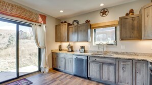 Una cocina con armarios de madera, lavavajillas y ventana con vista al exterior.