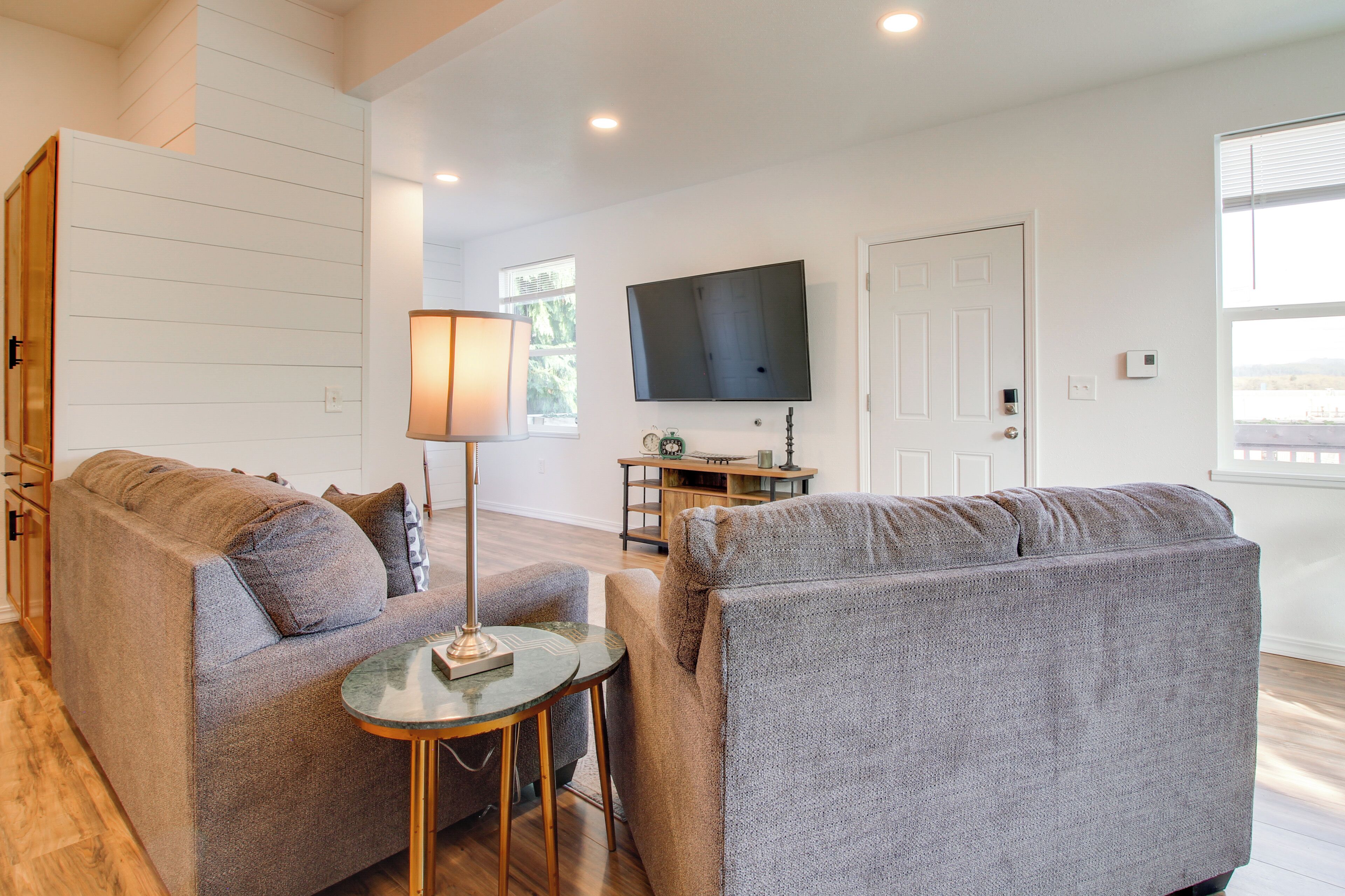 A modern living room with two sofas, a coffee table, a TV, and a door.