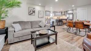 A modern living room with a grey sofa, a coffee table, and a dining area with a table and chairs. - Yakima Wine Country Haven: Near Hiking & Fishing! (Yakima)