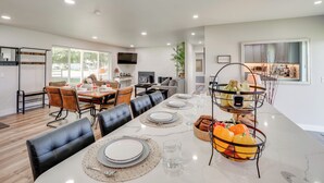 A modern dining area with a long table set for six, surrounded by black leather chairs. - Yakima Wine Country Haven: Near Hiking & Fishing! (Yakima)