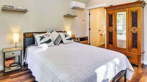 Un dormitorio con cama, mesita de noche, lámpara y armario.
