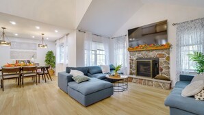 Una sala de estar moderna con un sofá modular, una mesa de comedor y una chimenea.