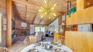 A dining area with a wooden ceiling, brick wall, and a table set for four.