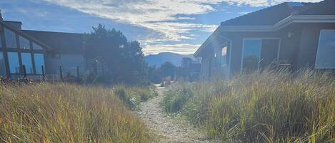 A pathway between two buildings with a clear sky and distant mountains.