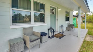 A porch with wicker furniture, two lanterns, and a green door. - Game Room, Yard: Home 3 Mi to Daytona Beach! (Holly Hill)