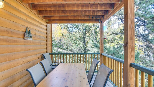 A wooden deck with a table and chairs, surrounded by a railing, overlooking a forested area. - Private Wooded Escape w/ Scenic Decks in Jefferson (Jefferson)