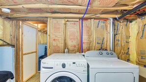 A laundry room with two Whirlpool washers, insulation on the walls, and exposed ceiling with electrical wiring. - Private Wooded Escape w/ Scenic Decks in Jefferson (Jefferson)