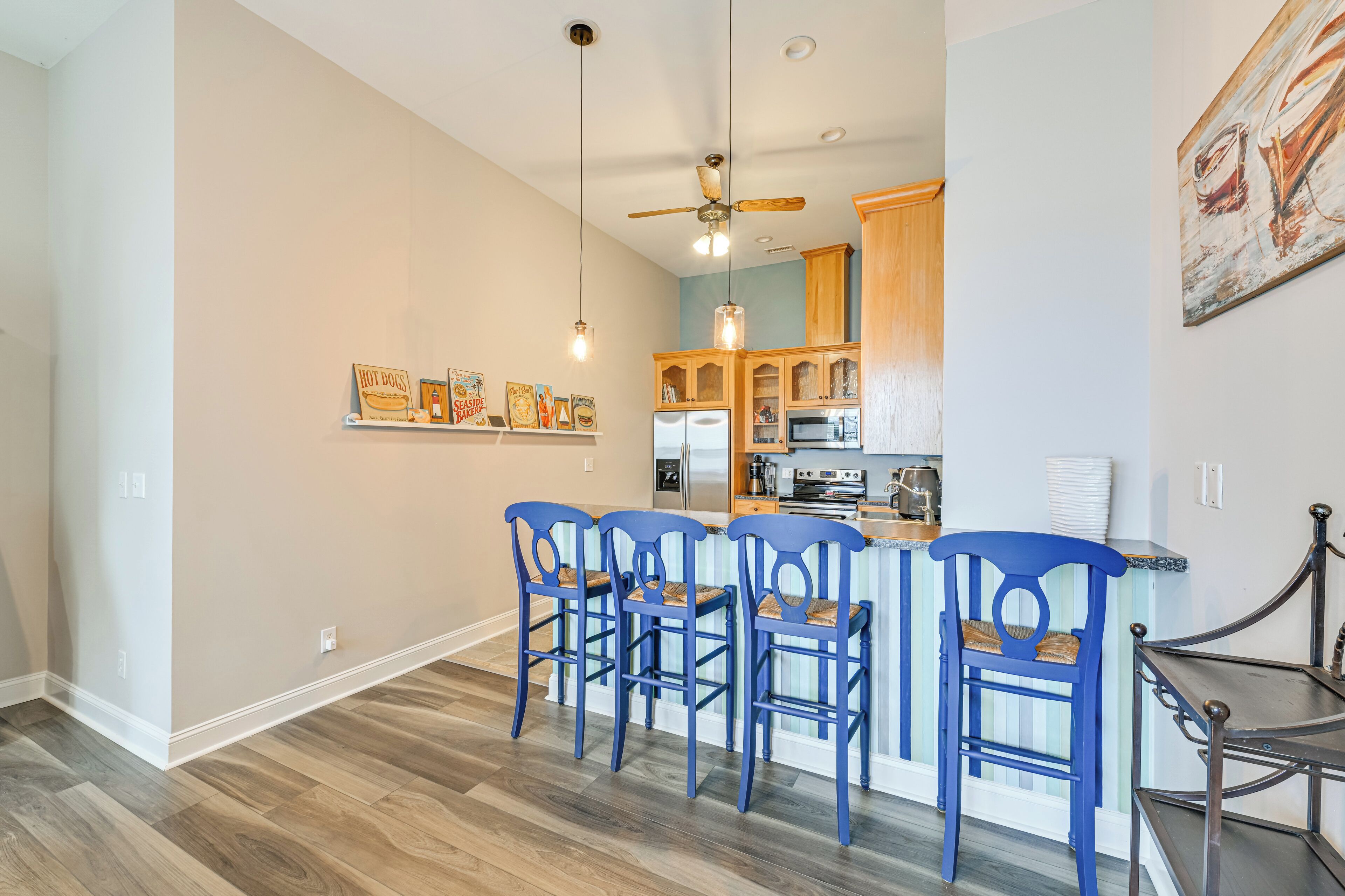 A modern kitchen with wooden cabinets, a central island, and a ceiling fan.