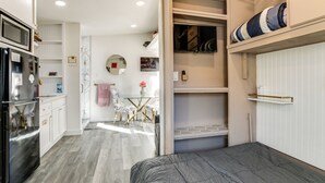 A compact kitchen with a refrigerator, microwave, and a dining area with chairs and a table. - Solo Escape w/ Hot Tub! 10 Mi to Dtwn Sacramento (Rio Linda)