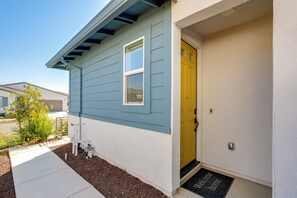 A house with a blue exterior, a yellow door, and a welcome mat.