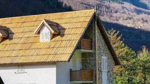 A mountain cabin with a sloped roof, stone walls, and a balcony. - Bujtina Tinari (Theth)
