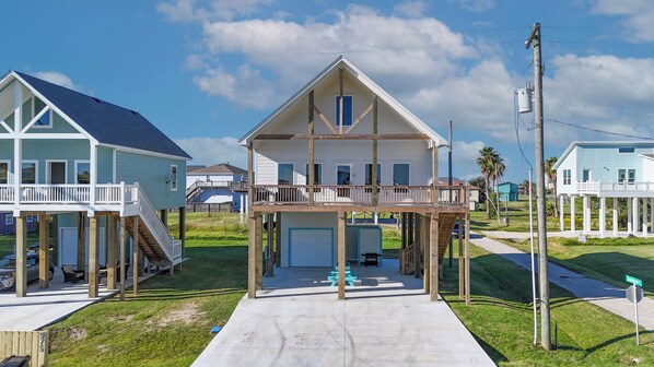 A beachfront house with a covered porch, a garage, and a small deck.