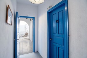 Ein Flur mit einer blauen Tür, die mit der Nummer 9 gekennzeichnet ist, einem Hängekorbstuhl und einem gerahmten Bild an der Wand.