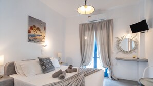 Une chambre d’hôtel avec un lit, une télévision, un miroir et un tableau au mur.
